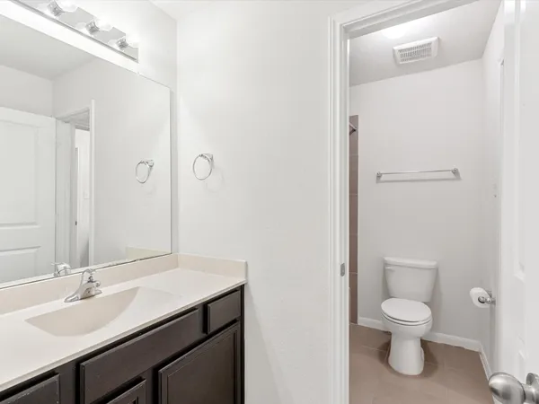 a bathroom with a toilet a sink and a mirror