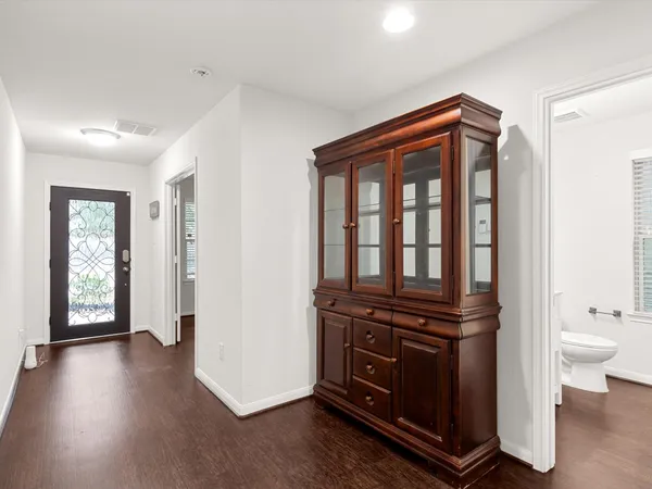 a view of a hallway with bathroom and wooden floor