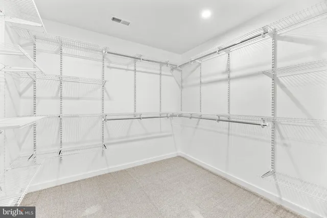 an empty room with windows and ceiling fan