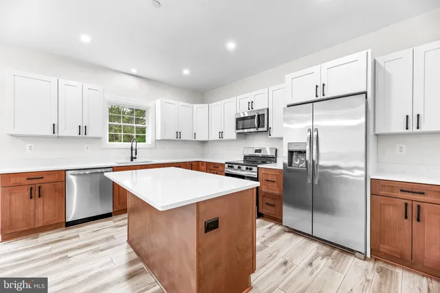 a kitchen with stainless steel appliances granite countertop a refrigerator and a stove