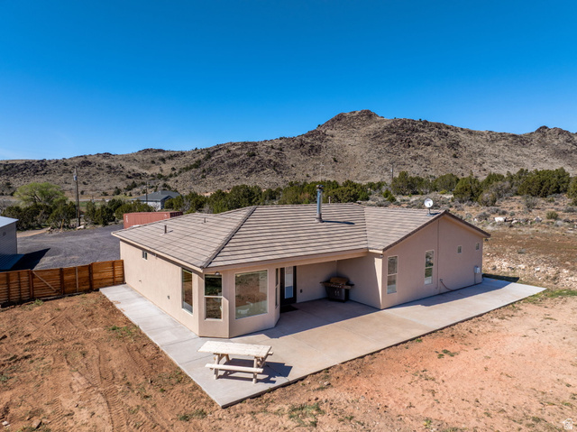 62 North Lucky 7 Road Veyo, UT 84782 - Photo 30 of 43 Back of house with stucco siding, a mountain view, and a patio area