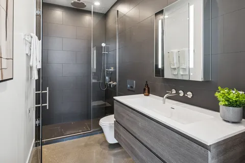 a bathroom with a sink a toilet and shower