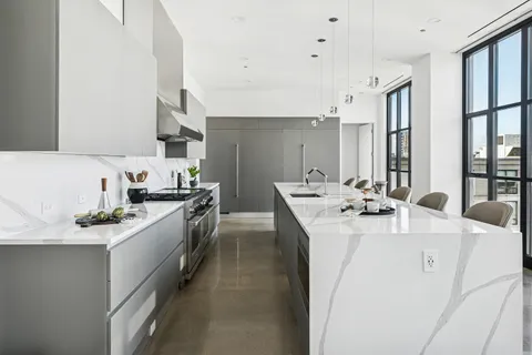 a kitchen with stainless steel appliances kitchen island a sink stove and cabinets