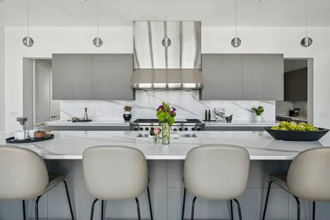 a kitchen with stainless steel appliances a table and chairs in it