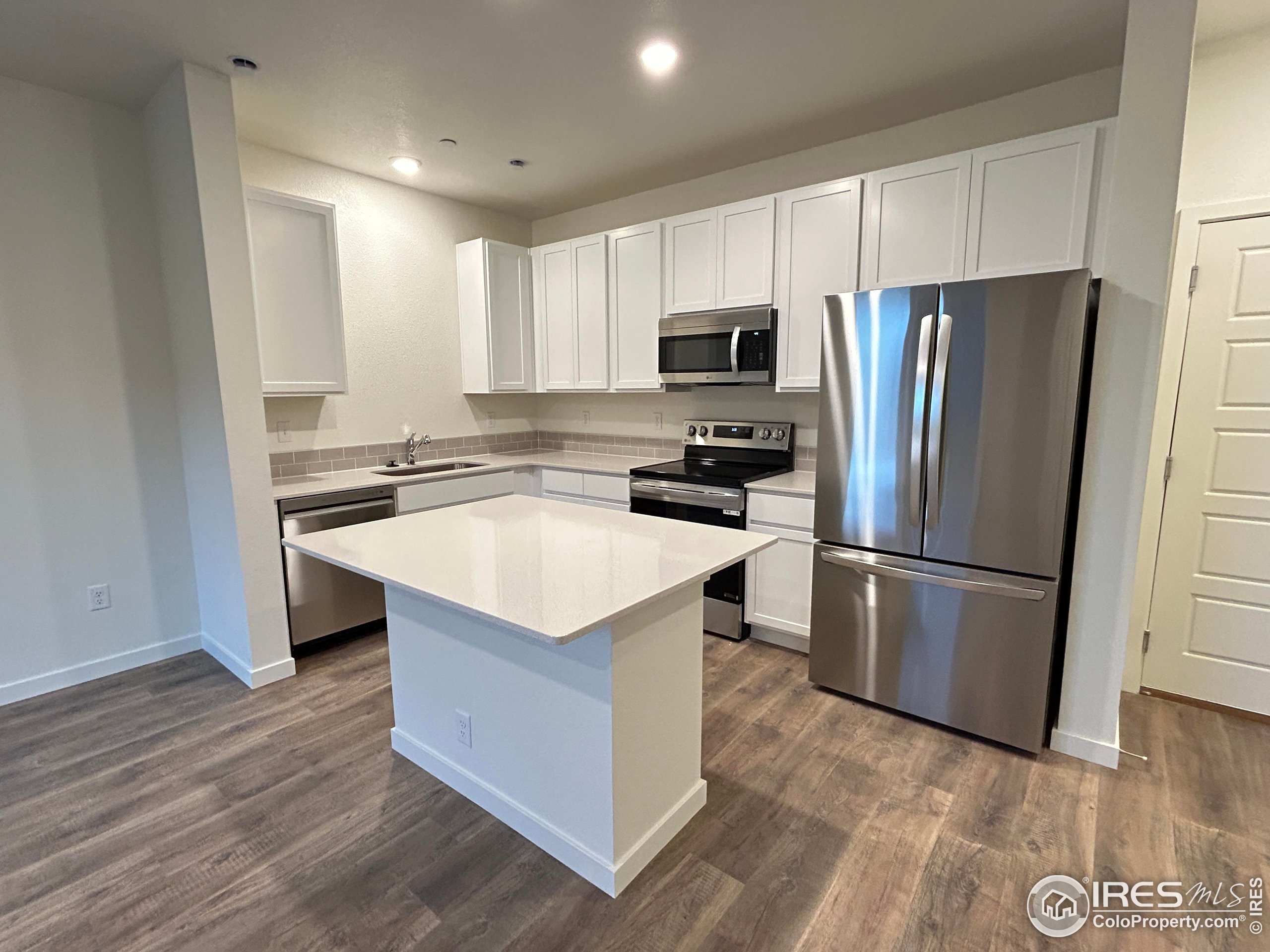 3905 Net Street Evans, CO 80620 - Photo 2 of 15 a kitchen with stainless steel appliances a refrigerator stove microwave and sink