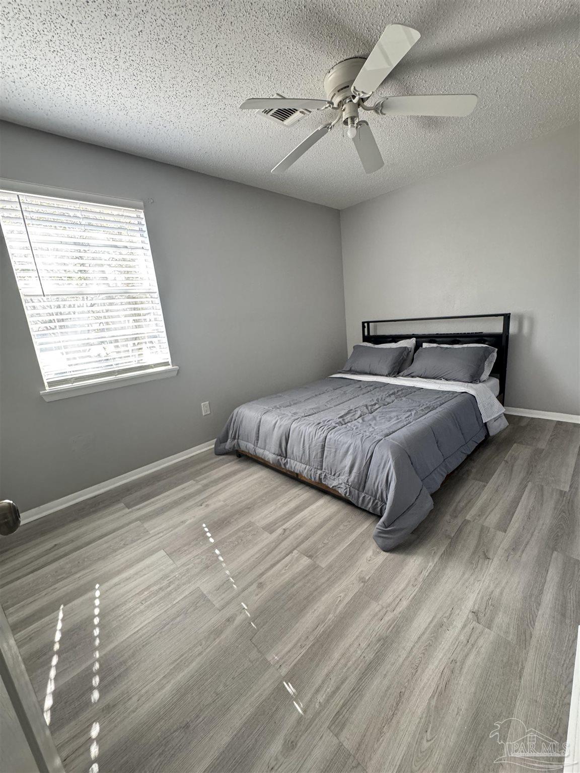 346 Quigley Road Pensacola, FL 32506 - Photo 14 of 28 a bedroom with a large bed and a chandelier