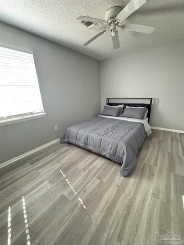 a bedroom with a bed and a ceiling fan