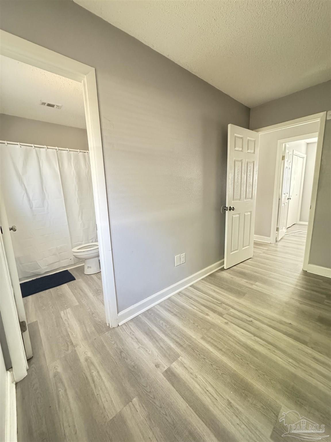 346 Quigley Road Pensacola, FL 32506 - Photo 21 of 28 an empty room with wooden floor and a window