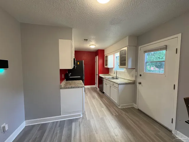 a kitchen with a refrigerator and a stove top oven