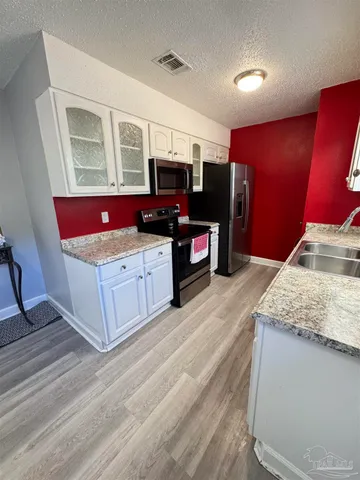 a kitchen with stainless steel appliances granite countertop a stove oven and a refrigerator