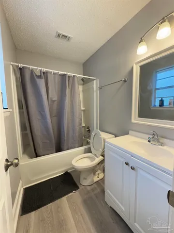 a bathroom with a sink a toilet a mirror and shower