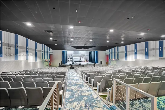 a large room with pool table and windows