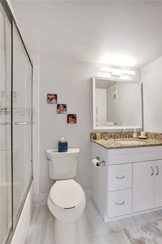 a bathroom with a granite countertop toilet sink and a mirror