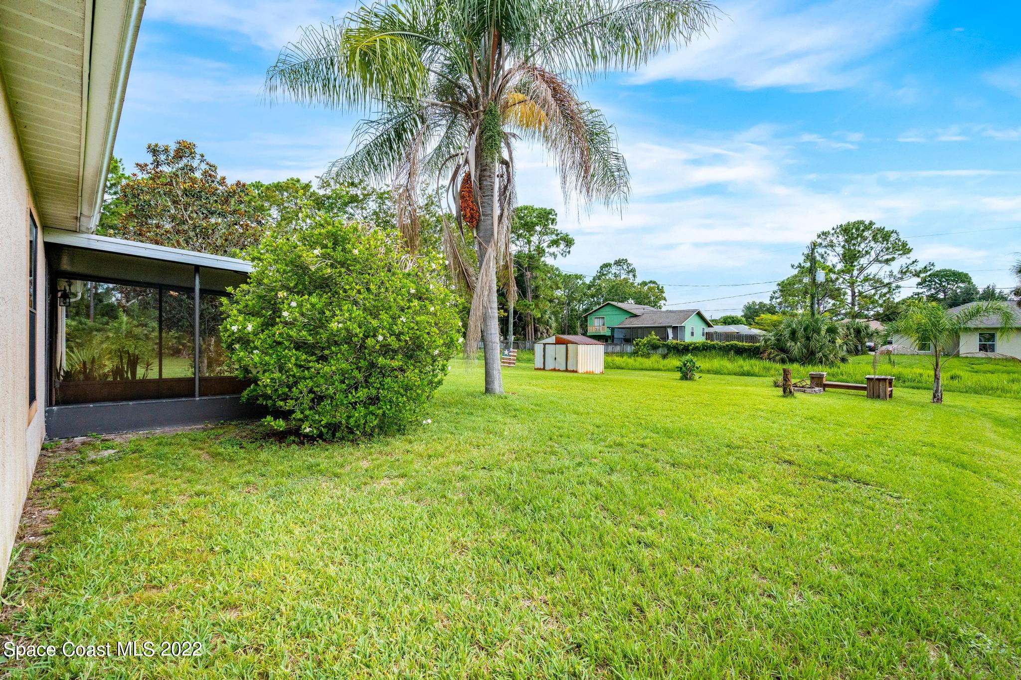 1355 Seabold Road Southwest Palm Bay, FL 32908 - Photo 14 of 22 a view of a garden with a building in the background