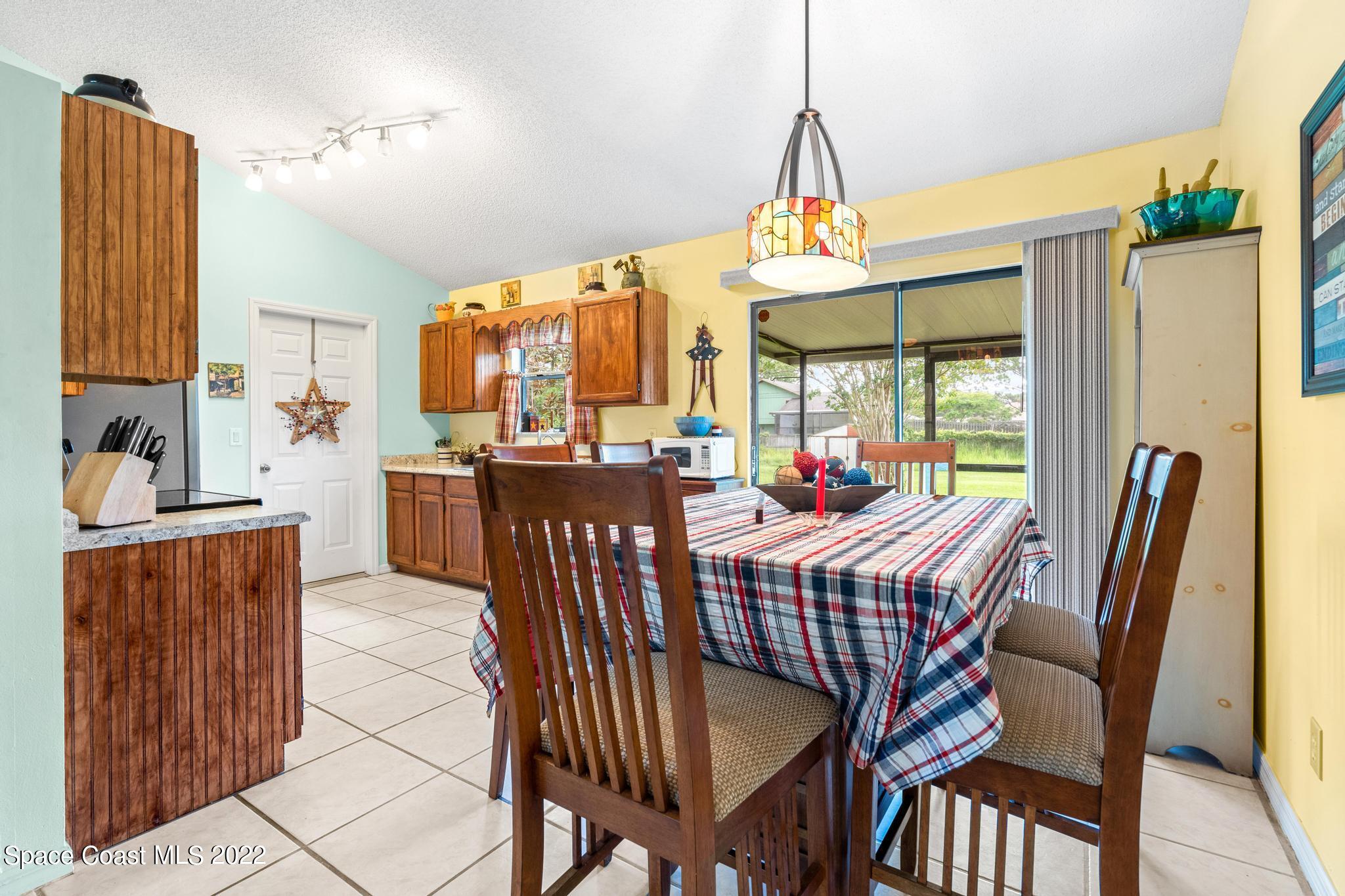 1355 Seabold Road Southwest Palm Bay, FL 32908 - Photo 4 of 22 a dining room with furniture a chandelier and window