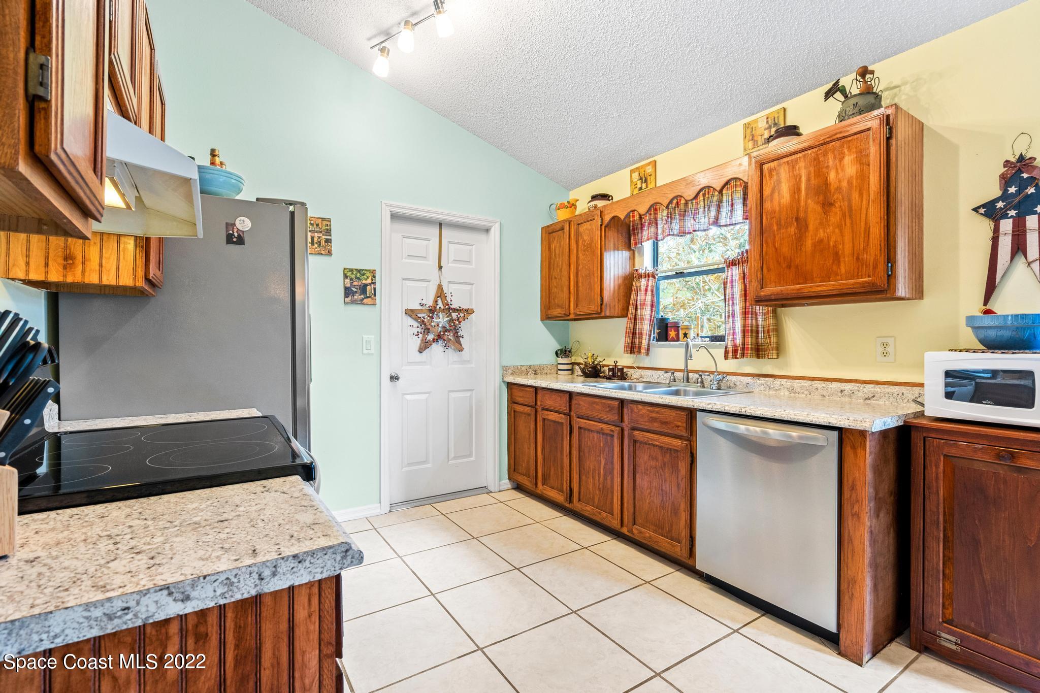 1355 Seabold Road Southwest Palm Bay, FL 32908 - Photo 5 of 22 a kitchen with stainless steel appliances granite countertop a refrigerator and a stove top oven