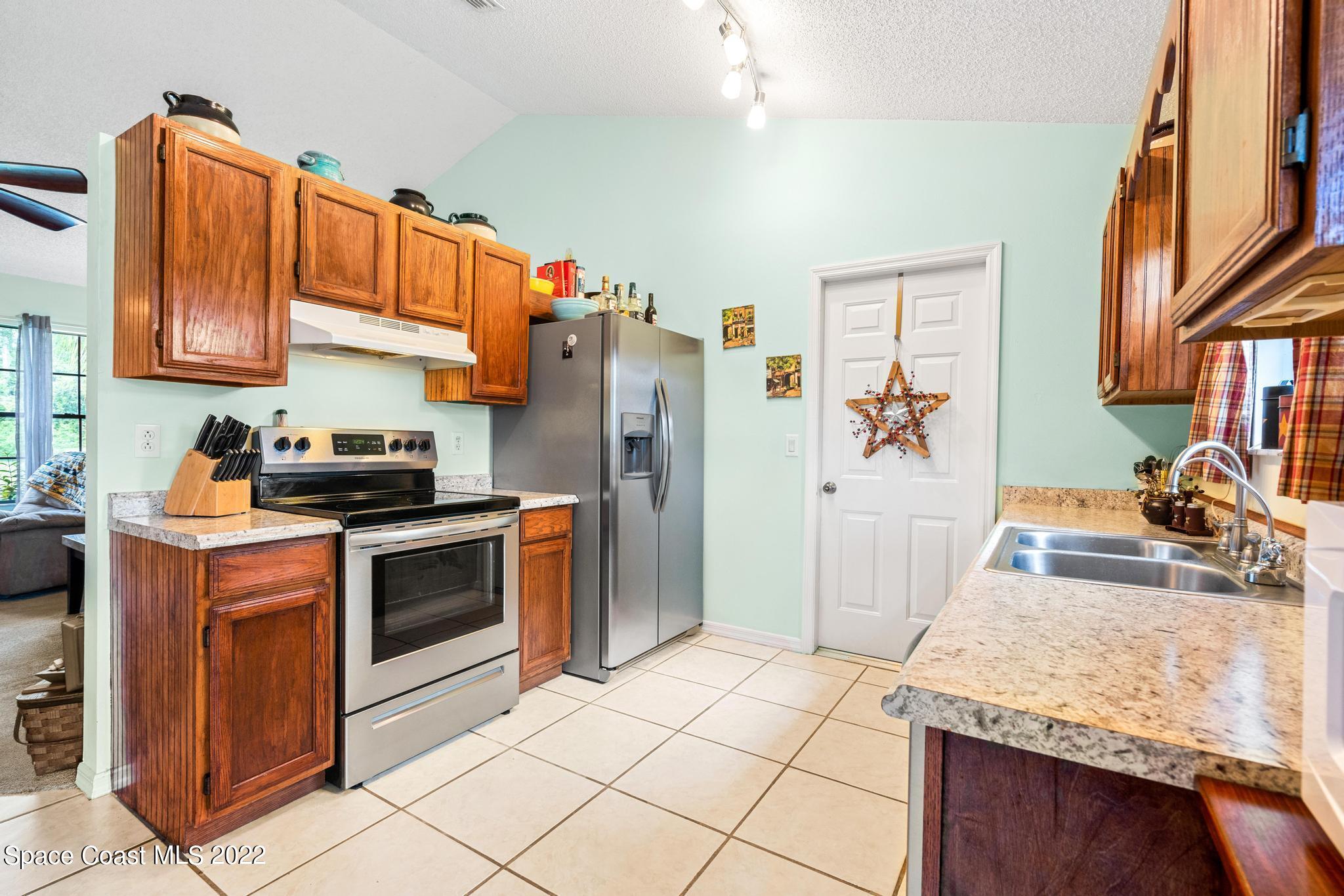 1355 Seabold Road Southwest Palm Bay, FL 32908 - Photo 6 of 22 a kitchen with stainless steel appliances granite countertop a sink stove and refrigerator