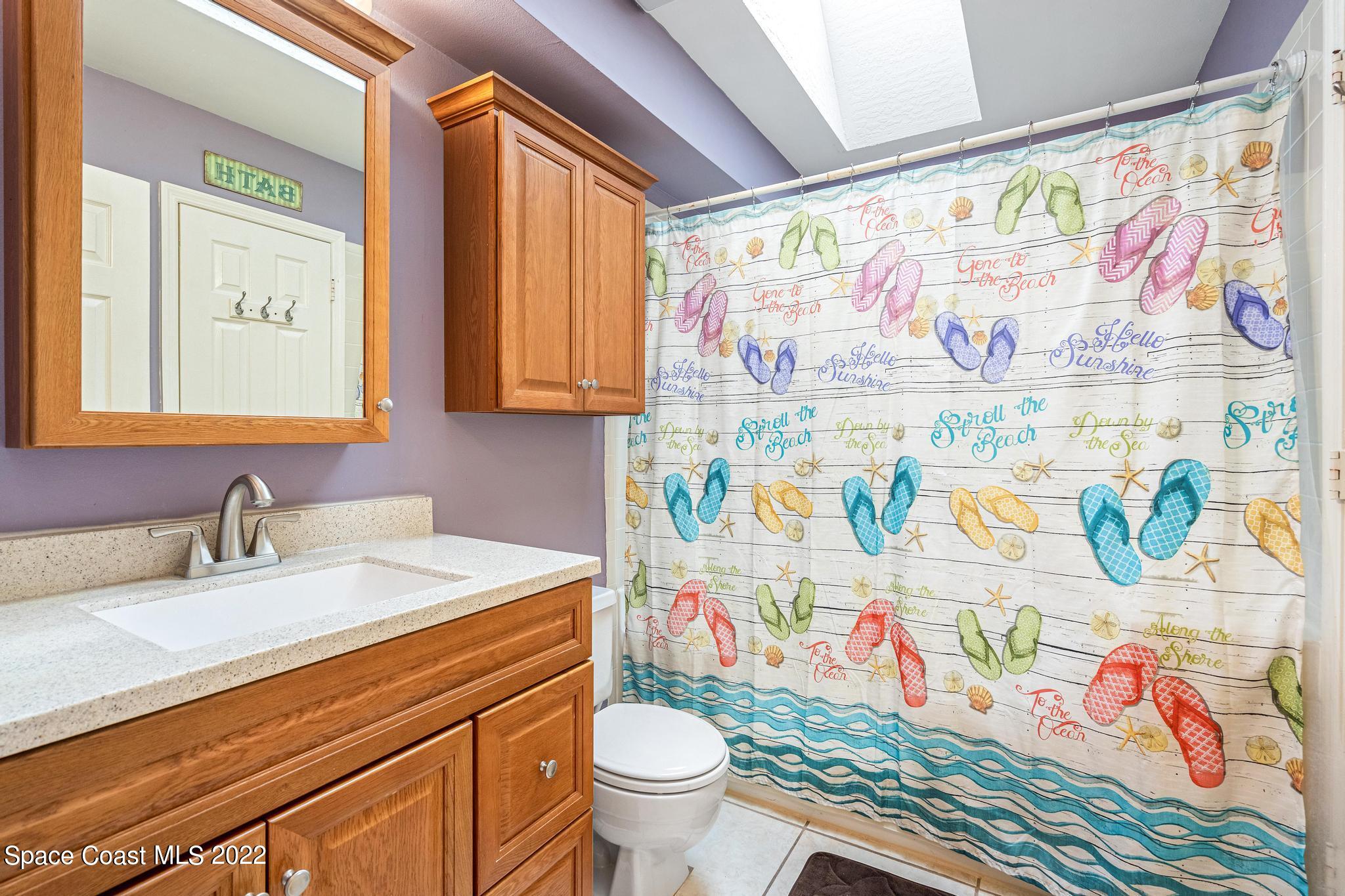 1355 Seabold Road Southwest Palm Bay, FL 32908 - Photo 8 of 22 a bathroom with a sink a toilet and a shower curtain