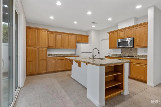 a kitchen with granite countertop a sink stove and cabinets