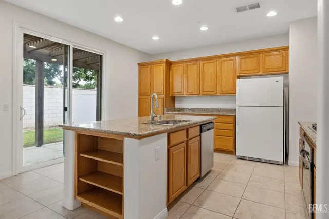 a kitchen with stainless steel appliances granite countertop a refrigerator a sink and a stove