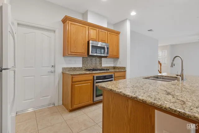 a kitchen with granite countertop a sink and a stove top oven