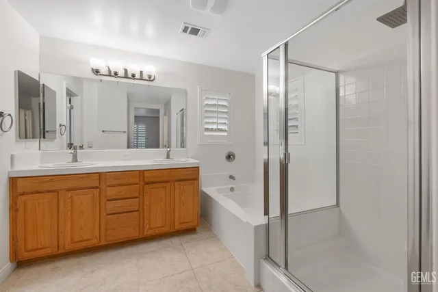 a spacious bathroom with a granite countertop sink a mirror and shower