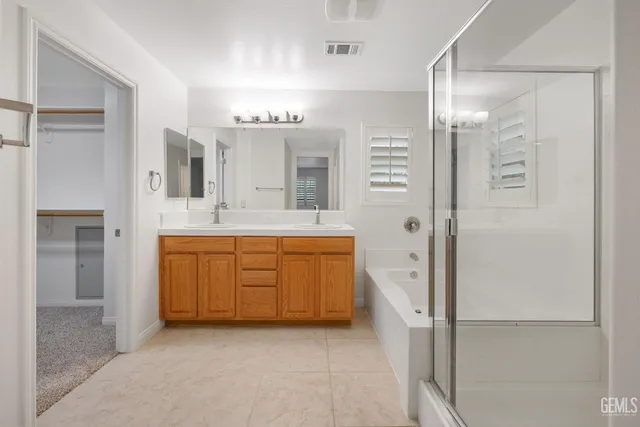 a bathroom with a tub sink vanity granite and a mirror