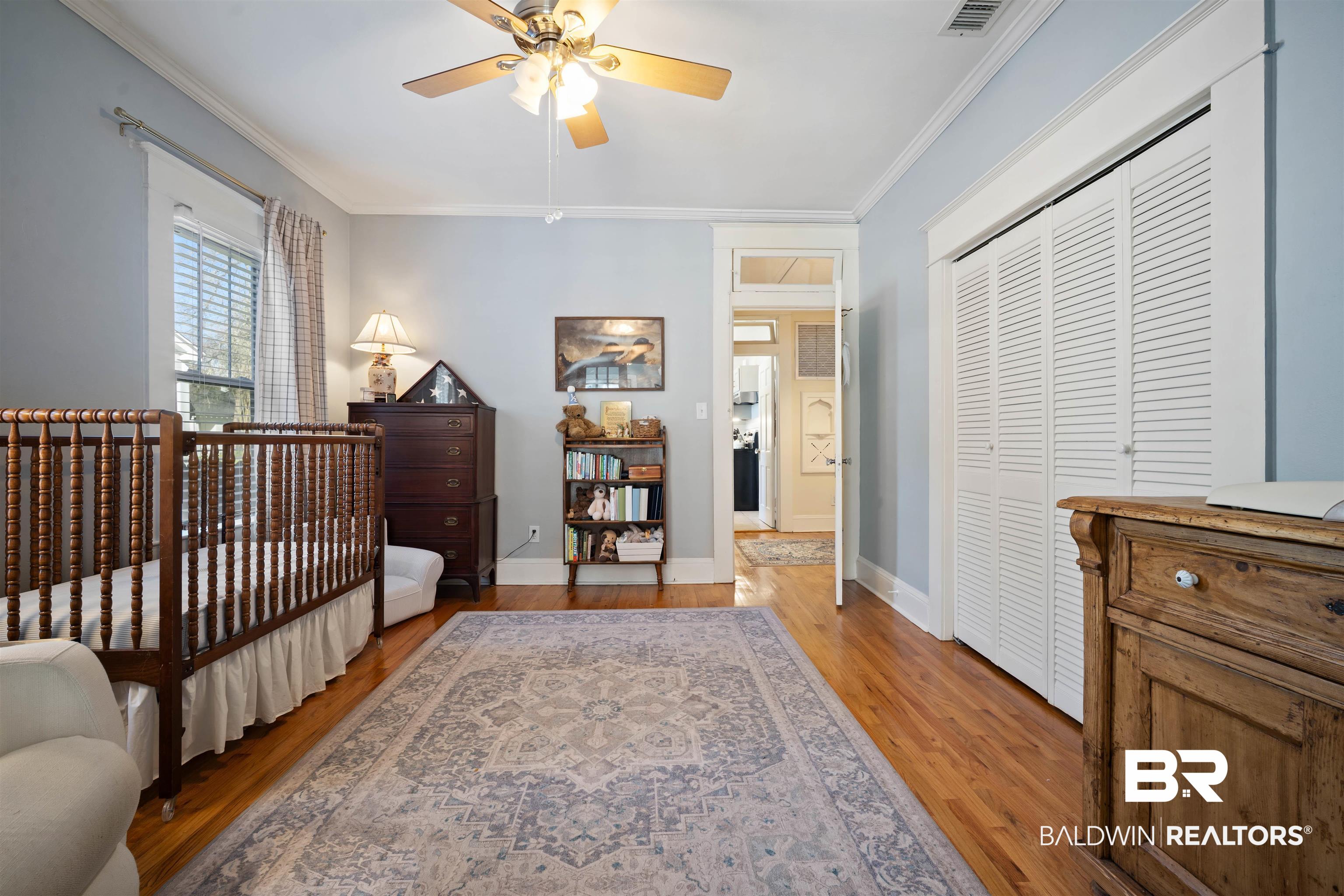 168 Mohawk Street Mobile, AL 36606 - Photo 23 of 31 Bedroom with crown molding, a closet, wood-type flooring, a crib, and ceiling fan