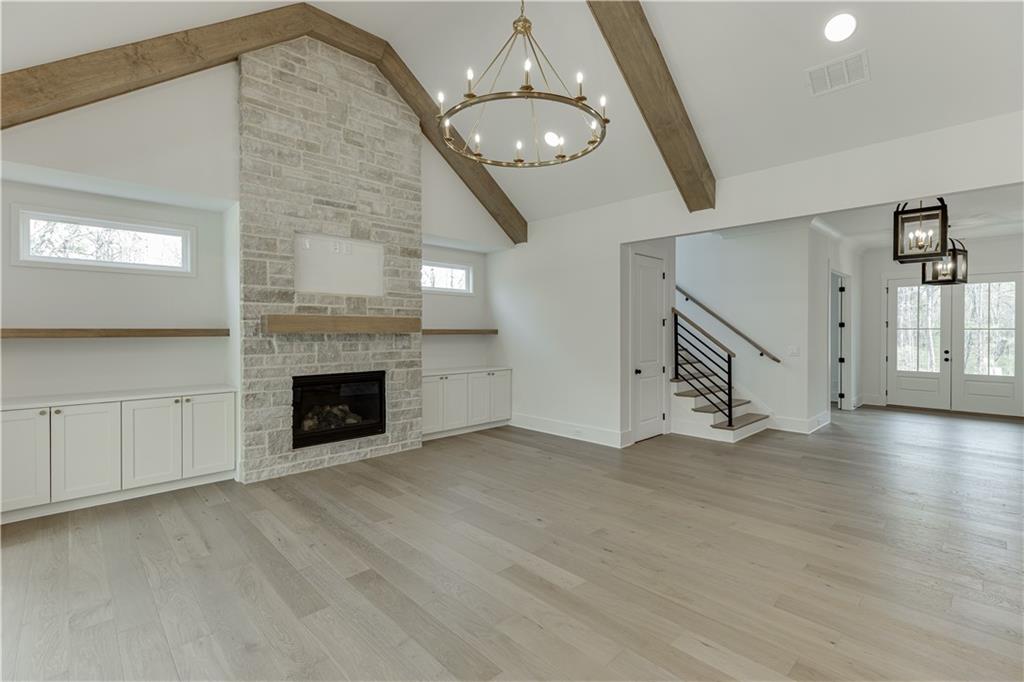 128 Ivey Trace Pendergrass, GA 30567 - Photo 12 of 57 an empty room with wooden floor fireplace and windows