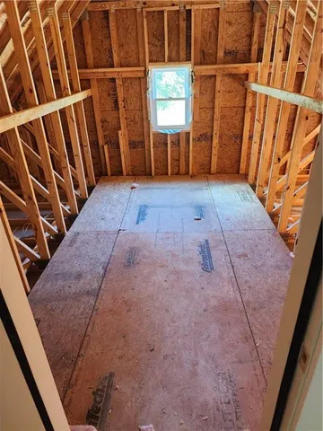 a view of an empty room with wooden floor and stairs