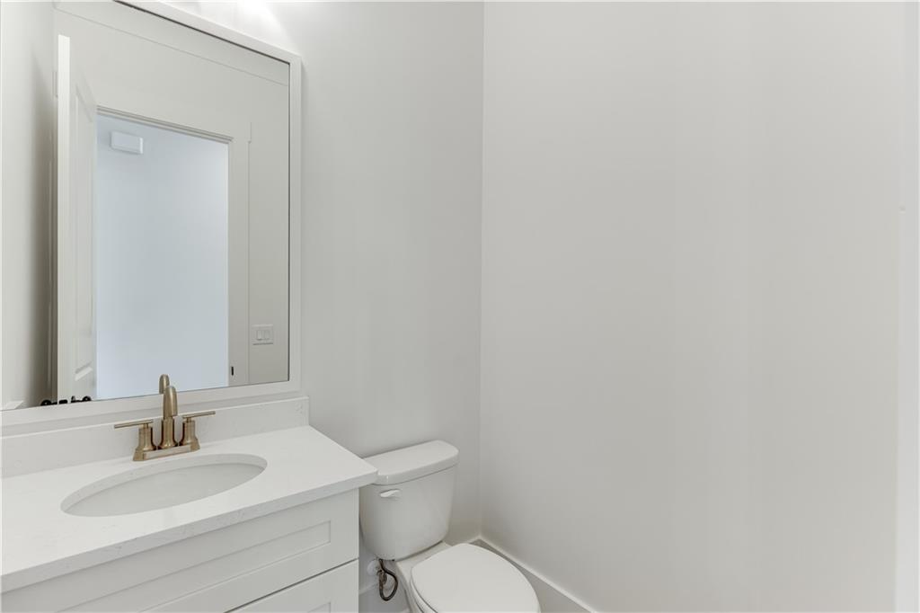 128 Ivey Trace Pendergrass, GA 30567 - Photo 24 of 57 a bathroom with a toilet sink vanity and mirror