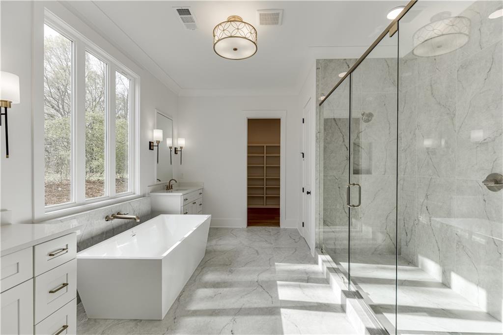 128 Ivey Trace Pendergrass, GA 30567 - Photo 28 of 57 a spacious bathroom with a tub shower and mirror