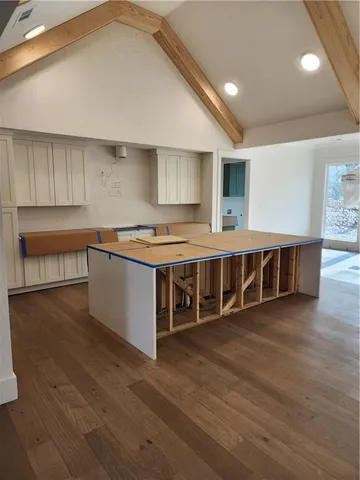 a large white kitchen with stainless steel appliances granite countertop a large counter top and a stove top oven