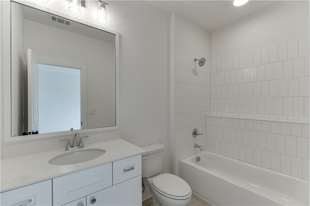 128 Ivey Trace Pendergrass, GA 30567 - Photo 48 of 57 a bathroom with a bathtub shower sink vanity mirror and toilet
