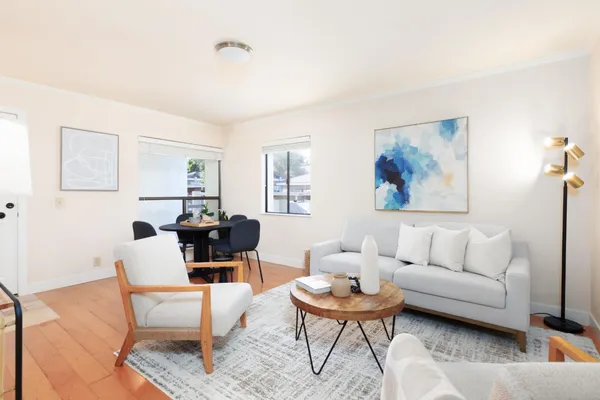 a living room with furniture and a painting on the wall