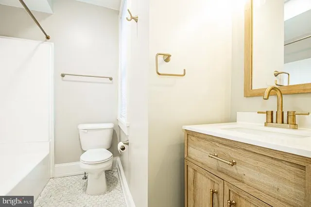 a bathroom with a toilet sink vanity and mirror