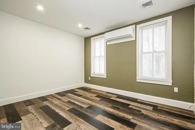 a view of a room with wooden floor and windows