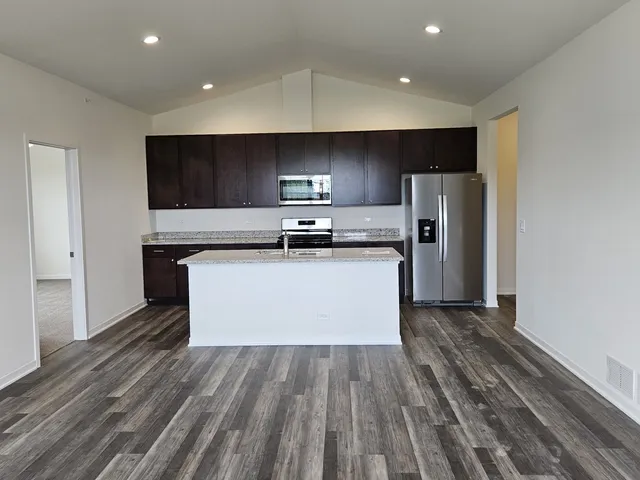 a kitchen with stainless steel appliances a refrigerator and a stove top oven