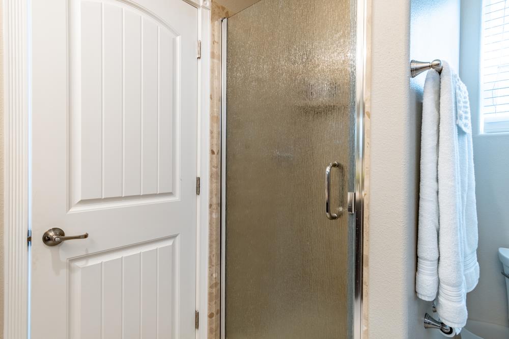 112 Springtime Circle Hollister, CA 95023 - Photo 25 of 63 a bathroom with a glass shower door