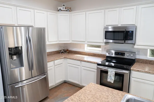 a kitchen with stainless steel appliances white cabinets and a stove