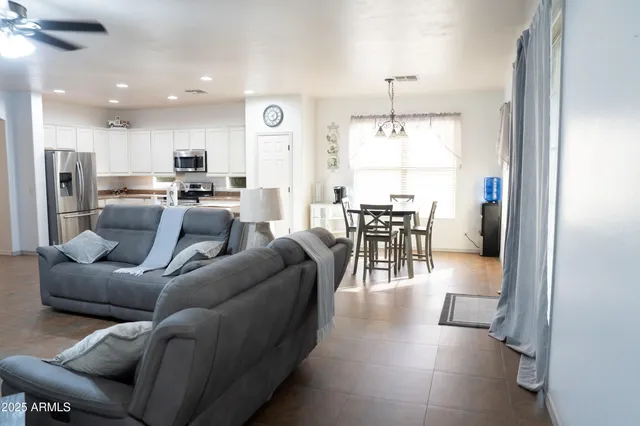 a living room with furniture and a dining table with kitchen view