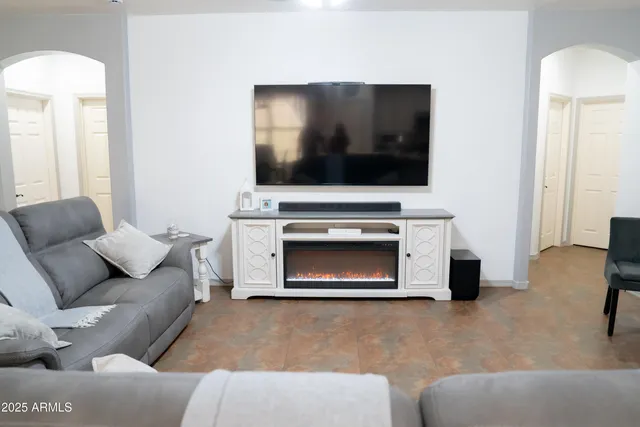 a living room with furniture a flat screen tv and a fireplace