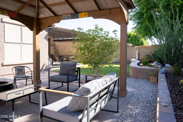 a view of a patio with a table chairs potted plants and palm tree