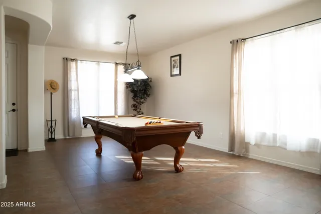 a room with pool table and windows