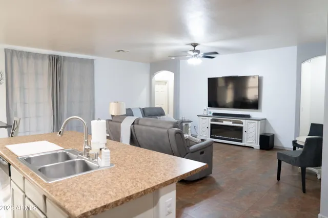 a kitchen with a appliances a sink and a living room view