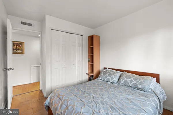 a large bed in a bedroom next to a cabinet