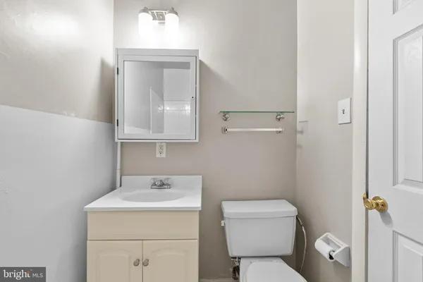 a bathroom with a toilet sink and mirror