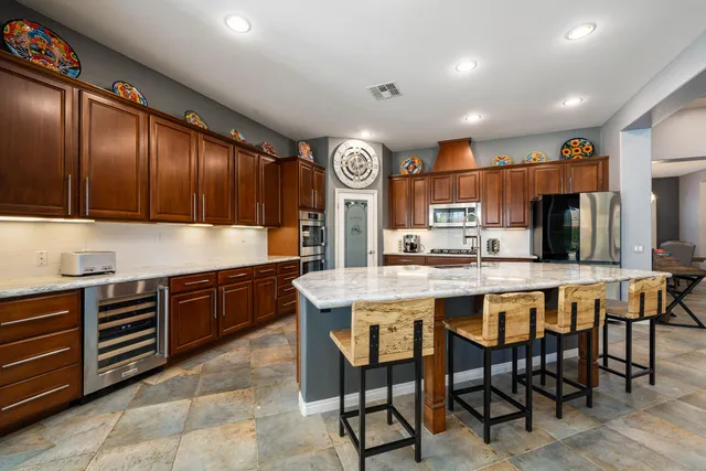 a large hall with stainless steel appliances lots of counter furniture and a view of living room