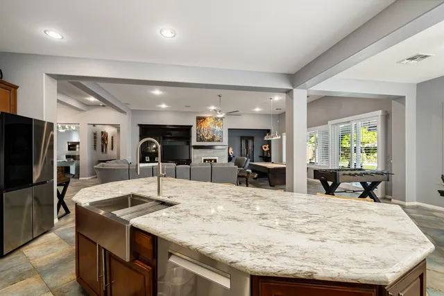 a kitchen with stainless steel appliances granite countertop a table chairs sink and cabinets