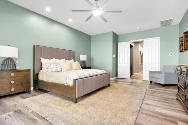 a spacious bedroom with a large bed and a dresser